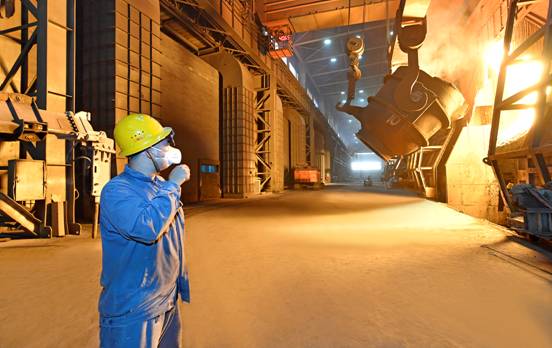 7月15日,河钢唐钢二钢轧厂转炉车间职工正在指挥天车进行装铁作业.